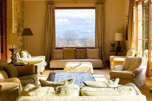 a living room with couches and a large window at Chateau d 'Echenevex, Geneva in Échenevex