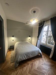 a bedroom with a bed and a large window at Appartement dans Maison de Maître in Schiltigheim