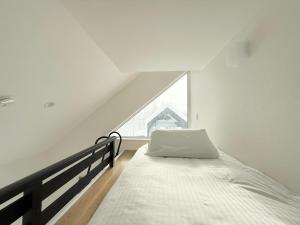 a white bedroom with a bed and a window at Niseko White Villa II Annupuri in Niseko