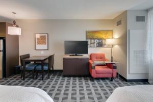 a hotel room with a desk and a chair and a television at TownePlace Suites by Marriott Kansas City Liberty in Liberty