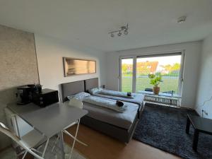 a bedroom with a bed and a table and a window at Ruhige sonnige Wohnung mit Rooftopterrasse nahe Universität in Gerbrunn