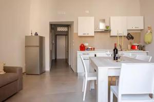 a kitchen with a refrigerator and a table and chairs at Giulia's Apartment in Bisceglie