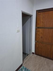 an empty room with a wooden door and a closet at Patcharin house 1 in Ko Lanta Yai +2 photos
