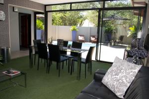 a living room with a couch and a table and chairs at A Contempo Guesthouse in Bloemfontein