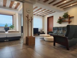 a living room with a couch and a bed at Palm Tree Villa in Seogwipo