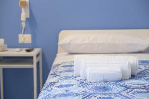 a bed with towels on it with a blue wall at Il Pendio B&B in Bisceglie