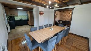 a dining room with a wooden table and blue chairs at Au pied du col in Luttenbach-près-Munster