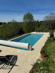 una piscina con sedie accanto di Le Pré aux Moines a Fontcouverte
