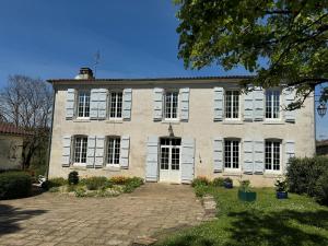 una grande casa in mattoni con persiane bianche di Le Pré aux Moines a Fontcouverte