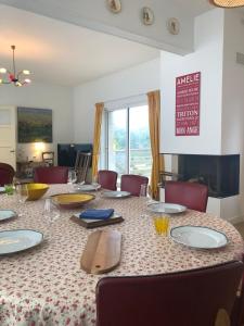 una mesa de comedor con platos y sillas y una ventana en Villa Triton - Vue mer, en Ambleteuse