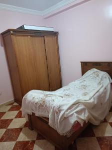 una camera da letto con un letto e un armadio in legno di Tanja balya a Tangeri