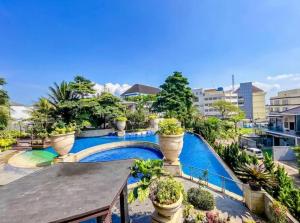 an apartment with a swimming pool and potted plants at Villa Fitsu Bhuvana in Ciawi Bogor