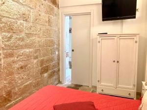 a bedroom with a brick wall and a white cabinet at Antica Pietra in Polignano a Mare
