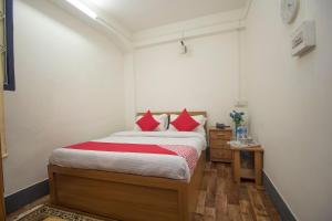 Un dormitorio con una cama con almohadas rojas. en Hotel O Ghakhel, en Ravangla 24 fotos más
