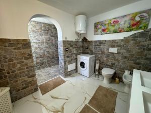 a bathroom with a toilet and a washing machine at DOLCE CASa 2 in Casalabate