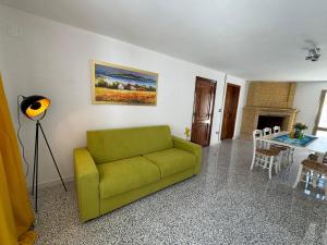 a living room with a green couch and a table at DOLCE CASa 2 in Casalabate +8 photos