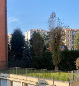 una valla frente a algunos árboles y edificios en Exclusive Deluxe Apt Between DUOMO & SAN SIRO, en Milán