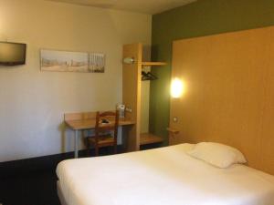 Habitación de hotel con cama, mesa y escritorio. en Hotel Bel Alp Manosque en Manosque