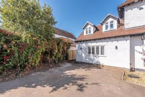 una casa con un garaje blanco y una valla en The Garden Apartment, en Bristol