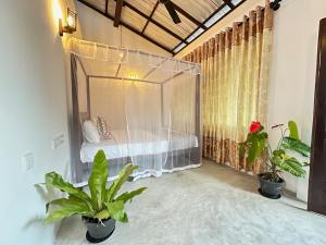 una camera con un letto in una stanza con piante di Sunliya Resort a Tangalle