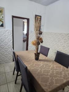 ein Esstisch mit einer Vase mit einer Pflanze darauf in der Unterkunft Casa no coração de Maricá in Maricá