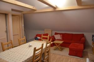 a living room with a red couch and a table at Szorcówka in Goniadz