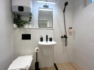 a white bathroom with a sink and a shower at Prime Stays at 92 Antim I Street in Sofia +74 photos