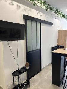 a black door in a room with a table at Studio rénové centre-ville - Tram et Parking gratuit in Saint-Jean-de-Védas