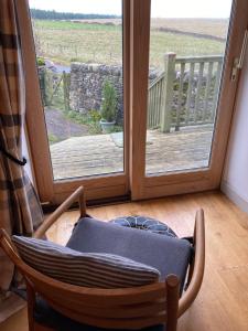 a rocking chair in front of a sliding glass door at The Cow House in Shap