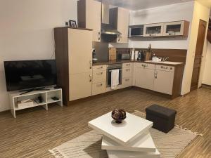 a living room with a large kitchen with a television at Comfortable Apartment in Beinheim
