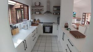 a kitchen with white counters and a stove top oven at The Milkwood Beach House in Zinkwazi Beach