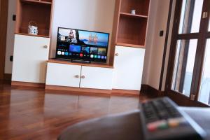 a living room with a tv on a white entertainment center at hopefco in Fiumicino