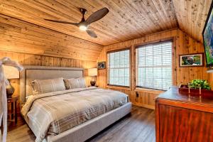 a bedroom with a bed and a ceiling fan at Waterfront A-Frame Cabin w Hot Tub, Outdoor Kitchen, Firepit Near Hiking & ATV Trails - 10 mins to Helen, GA in Sautee Nacoochee