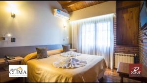 ein Hotelzimmer mit einem Bett mit gelben Laken und einem Fenster in der Unterkunft DOMUS AUDITORIUM in Villa Carlos Paz + 22 Fotos