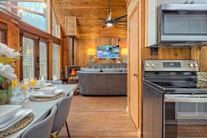 a kitchen and dining room with a table and a couch at Waterfront A-Frame Cabin w Hot Tub, Outdoor Kitchen, Firepit Near Hiking & ATV Trails - 10 mins to Helen, GA in Sautee Nacoochee