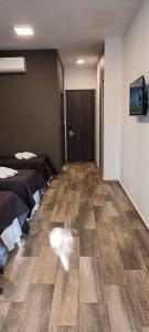 ein Zimmer mit zwei Betten und einem Hartholzboden in der Unterkunft DOMUS AUDITORIUM in Villa Carlos Paz