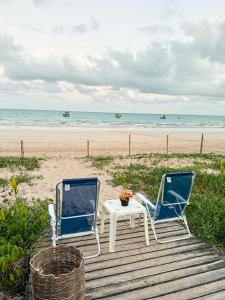 two chairs and a table on the beach at Maré Suítes Maragogi in Maragogi +37 photos