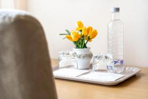 a tray with yellow flowers and a bottle on a table at Villa Ferrari, Le Betulle in San Maurizio dʼOpaglio