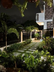 einen Garten mit Bäumen und Pflanzen in der Nacht in der Unterkunft Villa De Ciudad in Lapu Lapu City