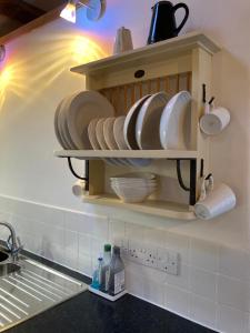 a kitchen with plates and dishes on a shelf at The Cow House in Shap