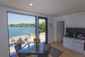 una cucina e una sala da pranzo con vista sull'acqua di Haus TAO, am See a Zirkow