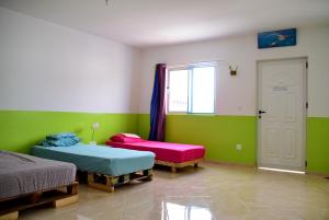 A bed or beds in a room at MEETING POINT- Tarrafal Group Reservations