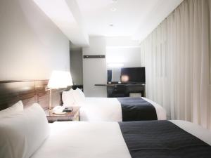 Postel nebo postele na pokoji v ubytování APA Hotel Akasaka Mitsuke