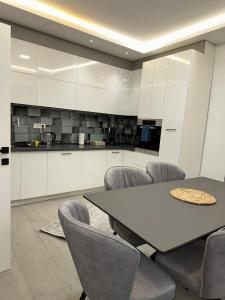 a kitchen with a table and chairs in a room at Villa Luca Free Parking in Sarajevo