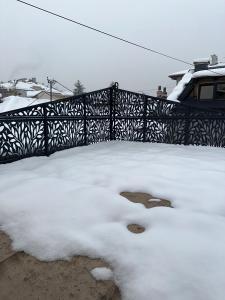 a pile of snow next to a black fence at Villa Luca Free Parking in Sarajevo
