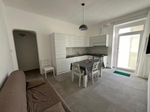 un salon avec une table et une cuisine dans l'établissement La casa di MeT, à Gallipoli