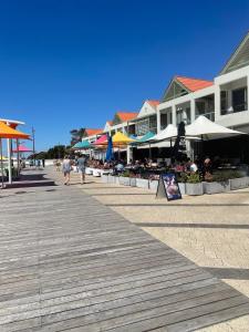 a boardwalk with buildings and people walking on it at a perfect weekend getaway in Rockingham