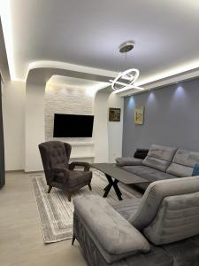 a living room with a couch and a table and chairs at Villa Luca Free Parking in Sarajevo