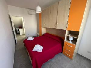- une petite chambre avec un lit rouge et des armoires dans l'établissement La casa di MeT, à Gallipoli 6 autres photos
