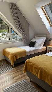 a bedroom with two beds and a window at Domki na Stronie C in Stronie Śląskie
